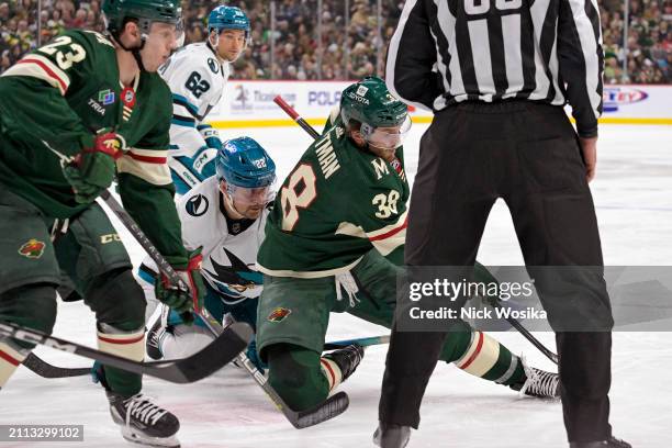 Ryan Hartman of the Minnesota Wild has his ankle twist under him during a faceoff with Ryan Carpenter of the San Jose Sharks during the second period...