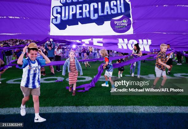 Patients run through the banner during the 2024 AFL Round 03 match between the North Melbourne Kangaroos and the Carlton Blues at Marvel Stadium on...