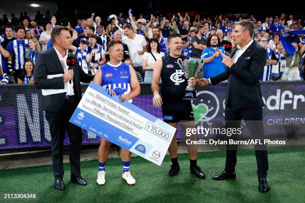 Past North Melbourne player Daniel Harris and Carlton Hall of Fame, Brendan Fevola, participate in the Kick for the Kids half time activation during...