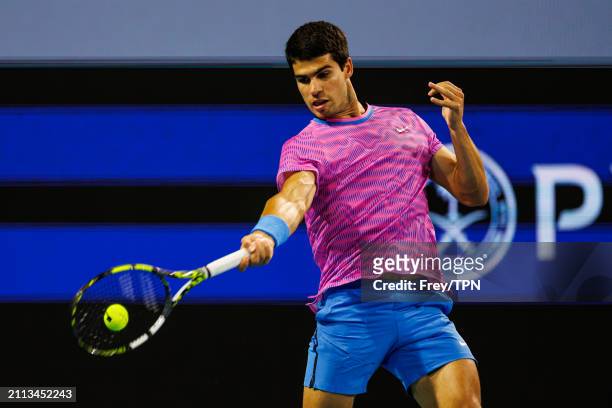 Carlos Alcaraz of Spain hits a forehand against Gael Monfils of France in the third round of the Miami Open at Hard Rock Stadium on March 25, 2024 in...