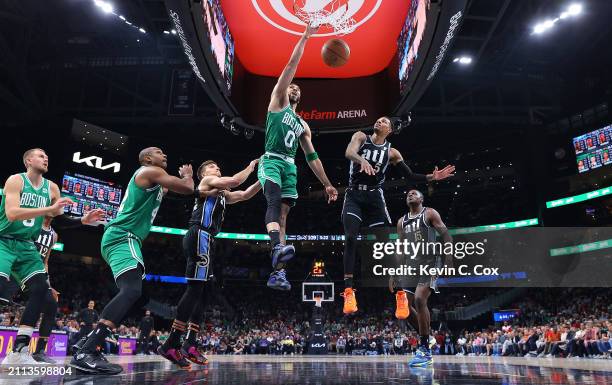 Jayson Tatum of the Boston Celtics dunks against Dejounte Murray and Bogdan Bogdanovic of the Atlanta Hawks during the fourth quarter at State Farm...