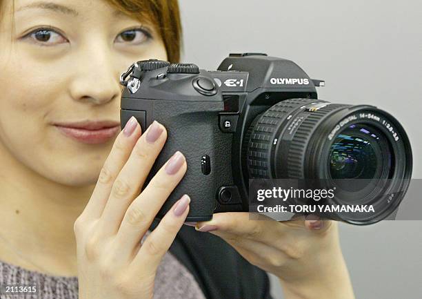 An employee of Japan's Olympus Optical Co., Ltd. Displays its new 5.5-megapixel digital still camera "E-1" in Tokyo, 25 June 2003. The E-1 is the...