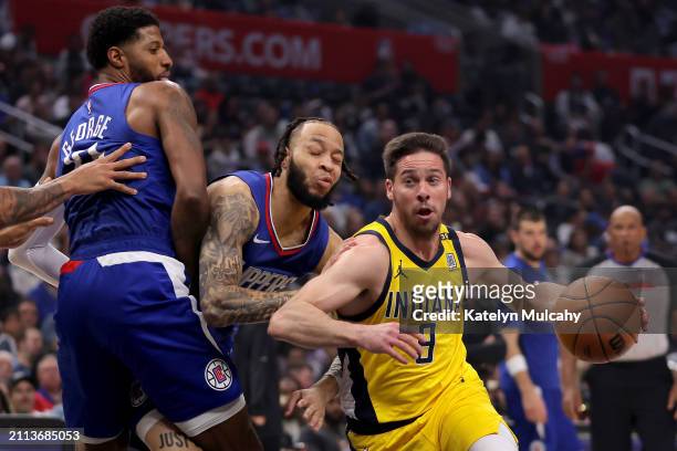 Amir Coffey of the Los Angeles Clippers collides into teammate Paul George while defending T.J. McConnell of the Indiana Pacers during the second...