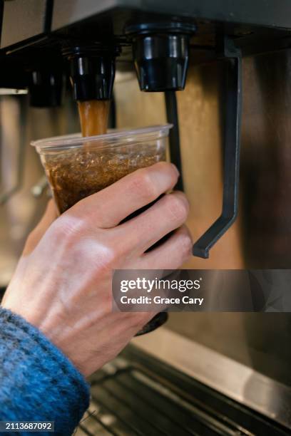 man fills cup with soda at restaurant - hand cola glass stock pictures, royalty-free photos & images
