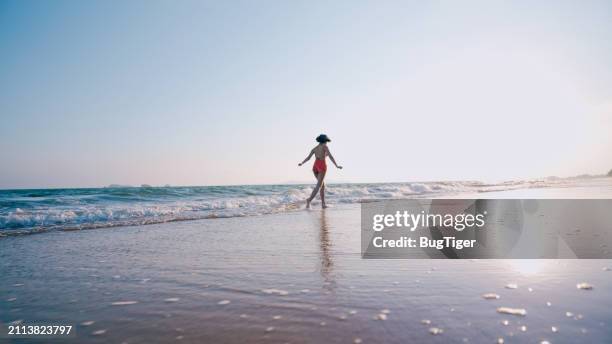 woman walking in bikini at beach on holiday. - feet run in ocean stock pictures, royalty-free photos & images