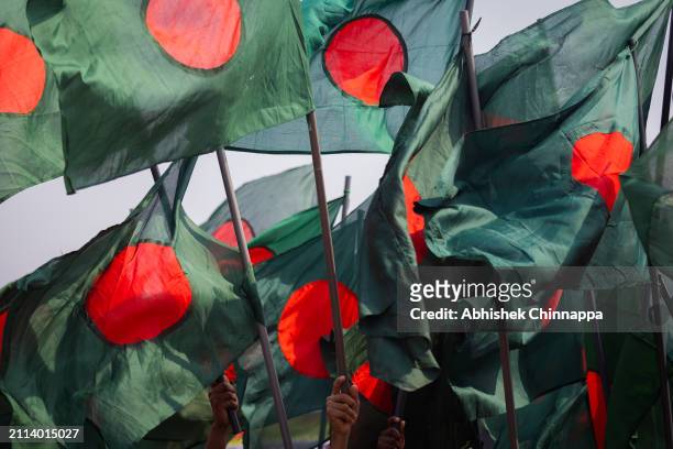 People wave the national flag of Bangladesh as they arrive to pay respect at the Jatiyo Sriti Shoudho to mark the nation's Independence Day on March...