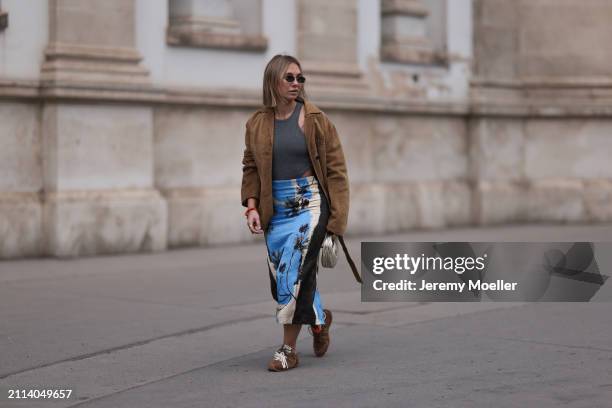 Karin Teigl seen wearing Fendi gold oval sunglasses, Michael Kors grey cotton body top, Zara blue / white / black print pattern midi long skirt, Miu...