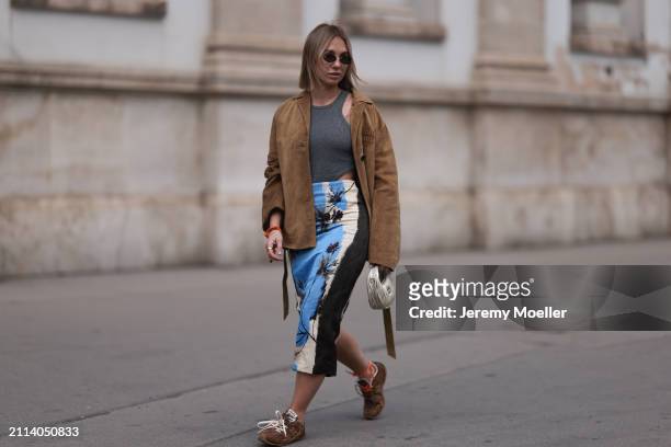 Karin Teigl seen wearing Fendi gold oval sunglasses, Michael Kors grey cotton body top, Zara blue / white / black print pattern midi long skirt, Miu...