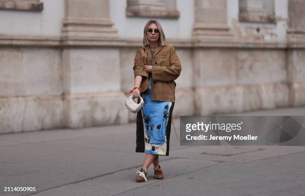 Karin Teigl seen wearing Fendi gold oval sunglasses, Michael Kors grey cotton body top, Zara blue / white / black print pattern midi long skirt, Miu...