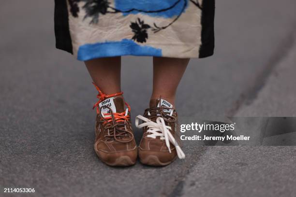 Karin Teigl seen wearing Zara blue / white / black print pattern midi long skirt and Miu Miu x New Balance brown suede leather sneakers, on March 23,...