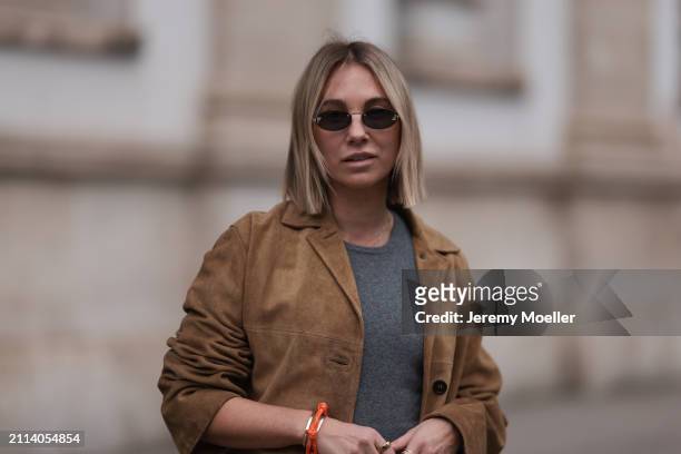 Karin Teigl seen wearing Fendi gold oval sunglasses, Michael Kors grey cotton body top, Miu Miu brown suede leather blazer jacket and Miu Miu orange...