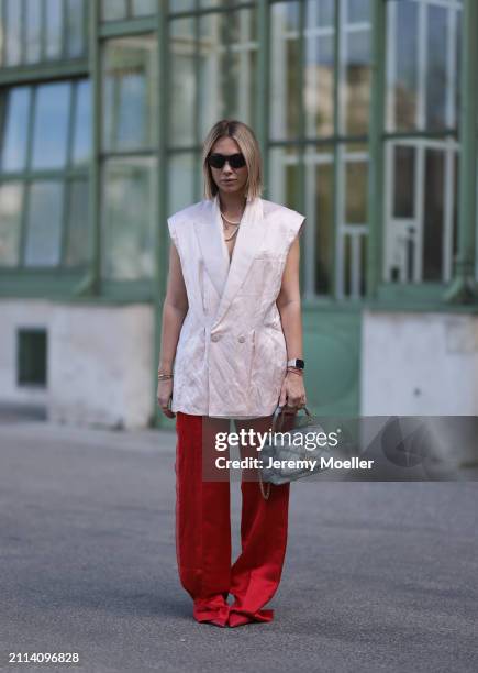 Karin Teigl seen wearing Bottega Veneta black / silver sunglasses, Chanel pearl chain, Zara light pink silk long suit vest, Zara red silk long wide...