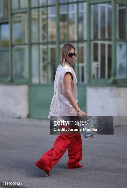 Karin Teigl seen wearing Bottega Veneta black / silver sunglasses, Chanel pearl chain, Zara light pink silk long suit vest, Zara red silk long wide...