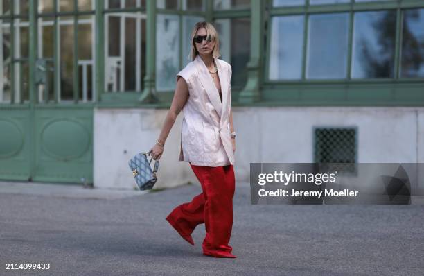 Karin Teigl seen wearing Bottega Veneta black / silver sunglasses, Chanel pearl chain, Zara light pink silk long suit vest, Zara red silk long wide...