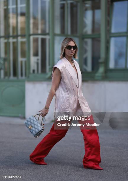 Karin Teigl seen wearing Bottega Veneta black / silver sunglasses, Chanel pearl chain, Zara light pink silk long suit vest, Zara red silk long wide...