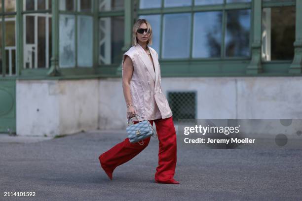 Karin Teigl seen wearing Bottega Veneta black / silver sunglasses, Chanel pearl chain, Zara light pink silk long suit vest, Zara red silk long wide...