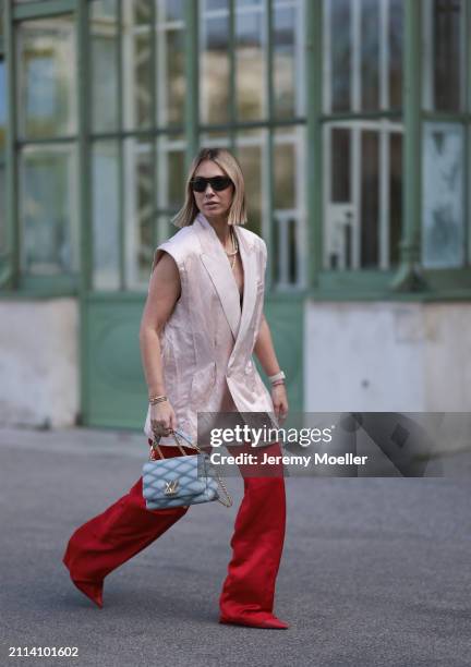 Karin Teigl seen wearing Bottega Veneta black / silver sunglasses, Chanel pearl chain, Zara light pink silk long suit vest, Zara red silk long wide...