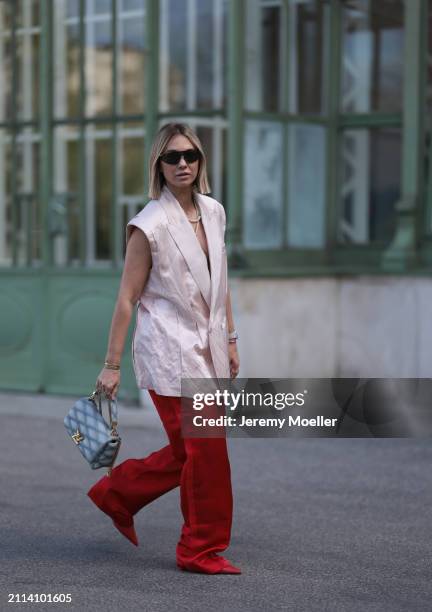 Karin Teigl seen wearing Bottega Veneta black / silver sunglasses, Chanel pearl chain, Zara light pink silk long suit vest, Zara red silk long wide...