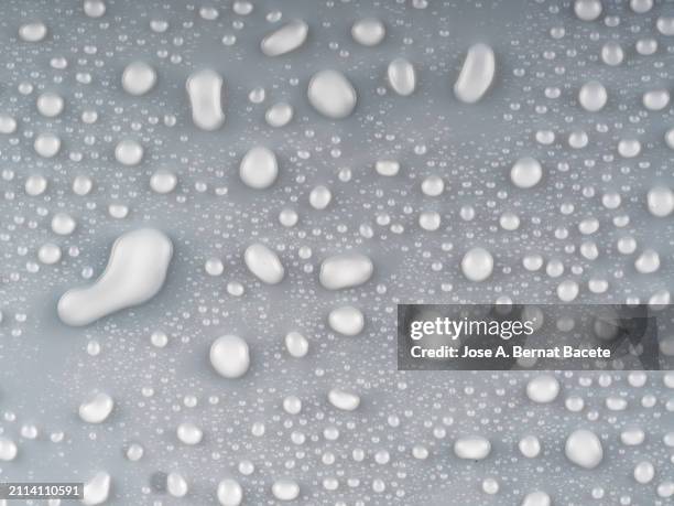 full frame of small drops and splashes of water on a solft gray background. - humidity stock pictures, royalty-free photos & images