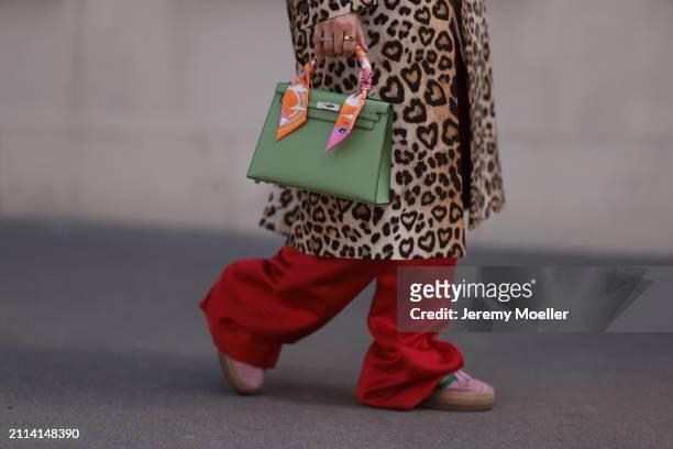 Karin Teigl seen wearing Zara red silk long wide leg pants, H&M Studios leopard print pattern long coat, Hermès Kelly light green leather bag with...