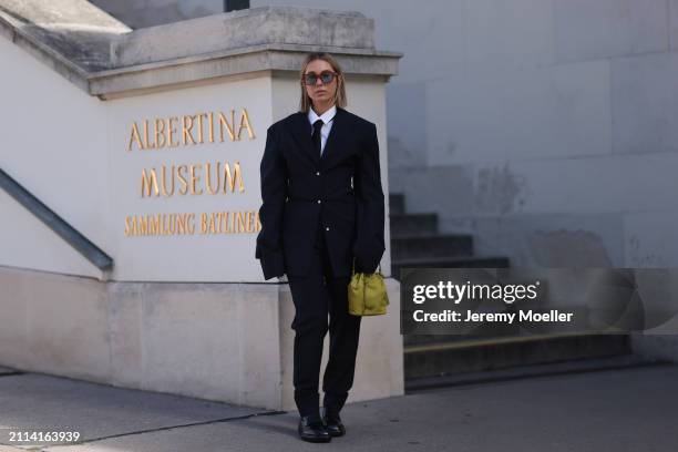 Karin Teigl seen wearing Jacques Marie Mage brown sunglasses with blue lenses, By Aylin Koenig white cotton buttoned shirt, H&M black tie, Prada navy...