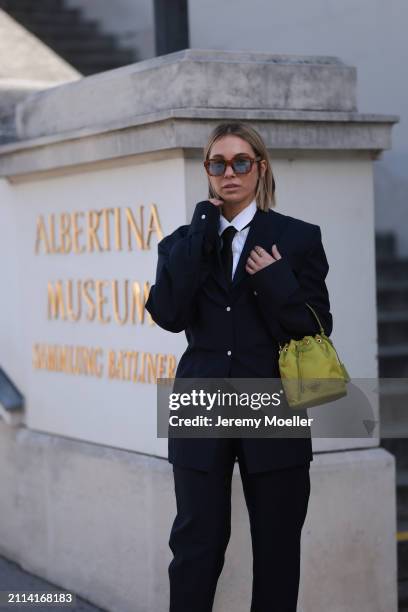 Karin Teigl seen wearing Jacques Marie Mage brown sunglasses with blue lenses, By Aylin Koenig white cotton buttoned shirt, H&M black tie, Prada navy...