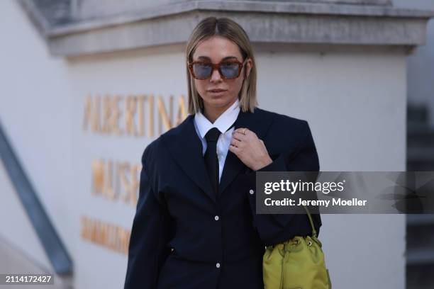 Karin Teigl seen wearing Jacques Marie Mage brown sunglasses with blue lenses, By Aylin Koenig white cotton buttoned shirt, H&M black tie, Prada navy...