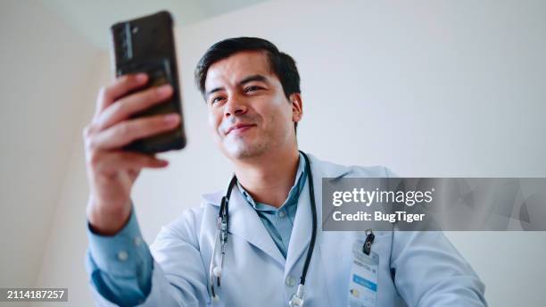 man, doctor using phone in clinic for online contact. - active lifestyle icons stock pictures, royalty-free photos & images