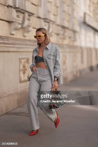 Karin Teigl seen wearing Loewe yellow sunglasses, gold necklaces, Milk White denim grey bral top, Agolde light grey denim buttoned jeans shirt,...