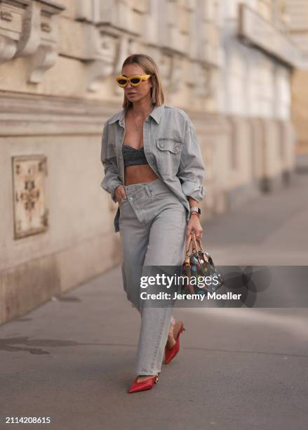 Karin Teigl seen wearing Loewe yellow sunglasses, gold necklaces, Milk White denim grey bral top, Agolde light grey denim buttoned jeans shirt,...