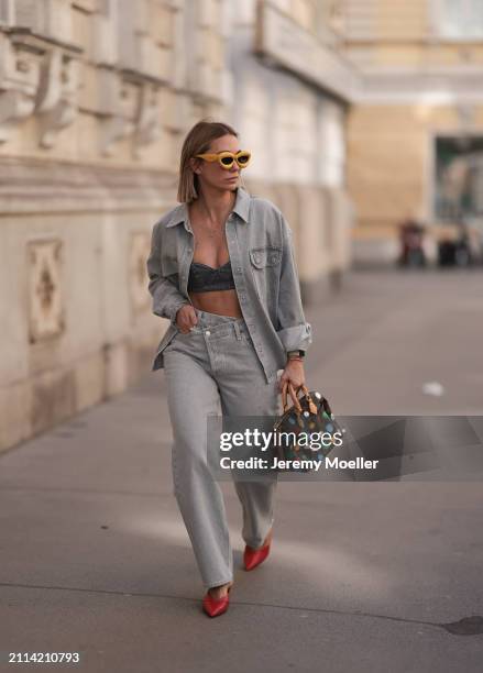 Karin Teigl seen wearing Loewe yellow sunglasses, gold necklaces, Milk White denim grey bral top, Agolde light grey denim buttoned jeans shirt,...