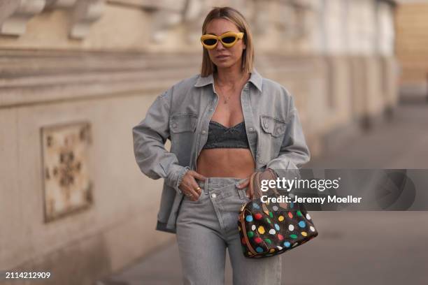 Karin Teigl seen wearing Loewe yellow sunglasses, gold necklaces, Milk White denim grey bral top, Agolde light grey denim buttoned jeans shirt,...