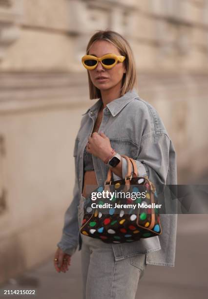 Karin Teigl seen wearing Loewe yellow sunglasses, gold necklaces, Milk White denim grey bral top, Agolde light grey denim buttoned jeans shirt,...