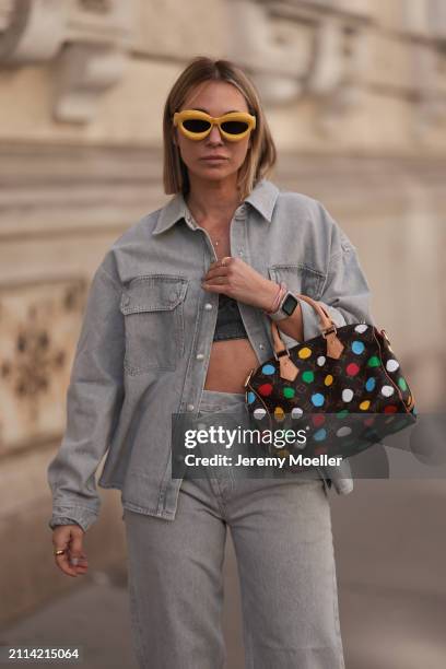 Karin Teigl seen wearing Loewe yellow sunglasses, gold necklaces, Milk White denim grey bral top, Agolde light grey denim buttoned jeans shirt,...