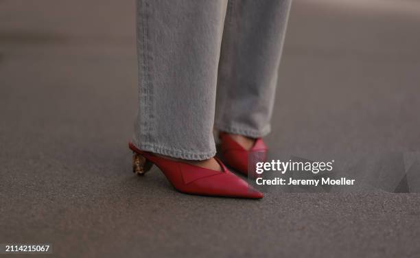 Karin Teigl seen wearing Agolde light grey denim straight leg pants and Zara red leather pumps / heels, on March 23, 2024 in Munich, Germany.