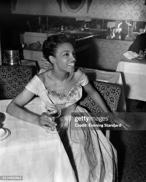 American jazz singer Maxine Sullivan holding an empty wine glass, February 6th 1954.