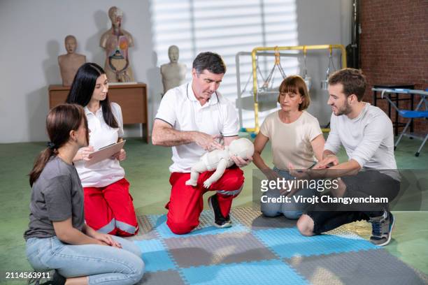 training in infant cpr on a mannequin - first aid class stock pictures, royalty-free photos & images