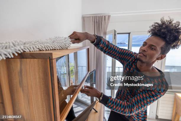 man dusting apartment - man dusting stock pictures, royalty-free photos & images