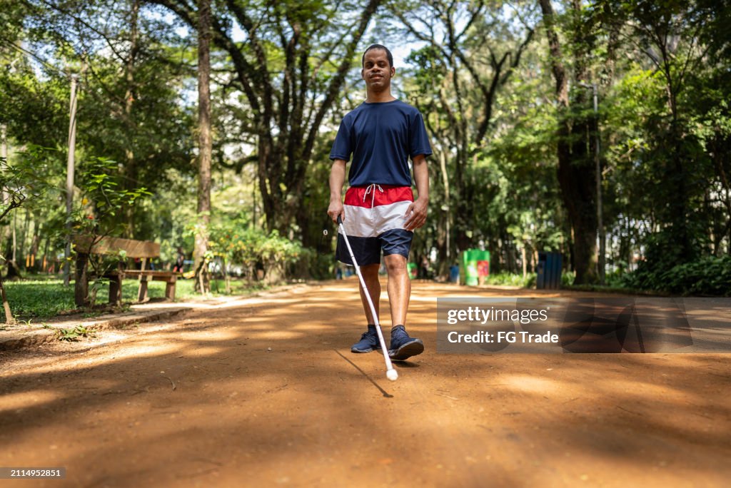 Visually impaired man walking on a public park