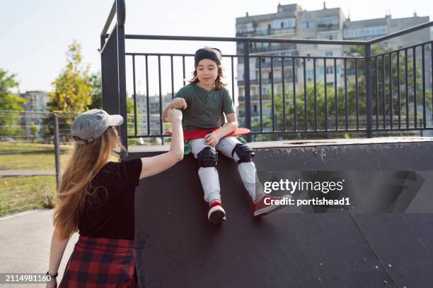 mother and son having skateboarding training in skateboard park - child saluting stock pictures, royalty-free photos & images