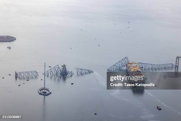 In an aerial view, the cargo ship Dali sits in the water after running into and collapsing the Francis Scott Key Bridge on March 26, 2024 in...