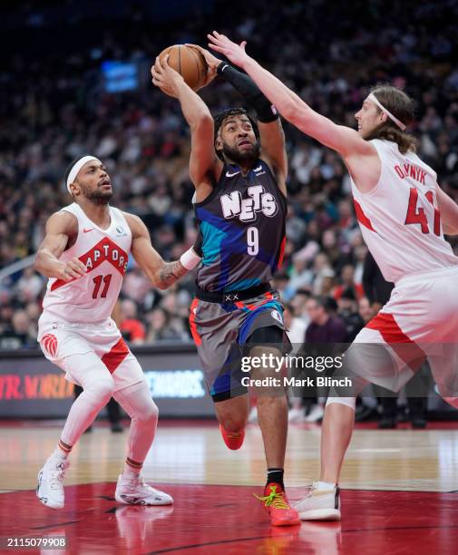 Trendon Watford of the Brooklyn Nets goes to the basket against Bruce Brown and Kelly Olynyk of the Toronto Raptors during the first half of their...
