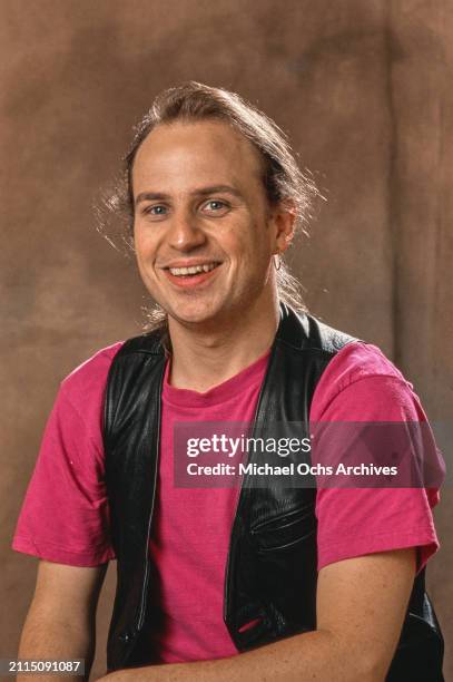 American comedian and actor Bobcat Goldthwait, wearing a black leather waistcoat over a pink t-shirt, poses during a studio portrait session for...