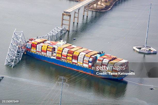 In an aerial view, the cargo ship Dali sits in the water after running into and collapsing the Francis Scott Key Bridge on March 26, 2024 in...