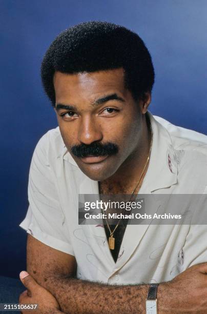 American actor Michael Dorn, wearing a white short-sleeve shirt, open at the collar, in a studio portrait, against a blue background, United States,...