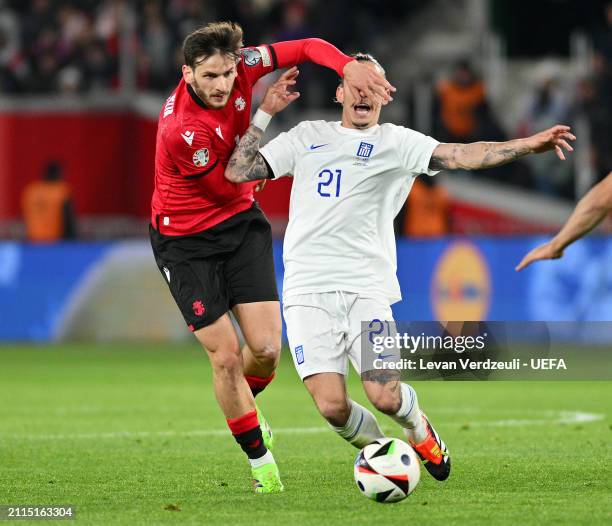 Kostas Tsimikas of Greece is challenged by Khvicha Kvaratskhelia of Georgia during the UEFA EURO 2024 Play-Offs final match between Georgia and...