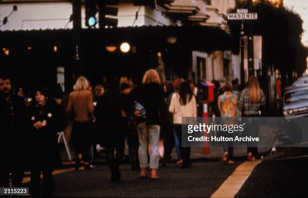 People cross an intersection in the Haight Ashbury nieghborhood of San Francisco, California, late 1960s.