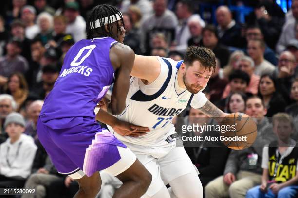 Luka Doncic of the Dallas Mavericks drives into Taylor Hendricks of the Utah Jazz during the second half of a game at Delta Center on March 25, 2024...