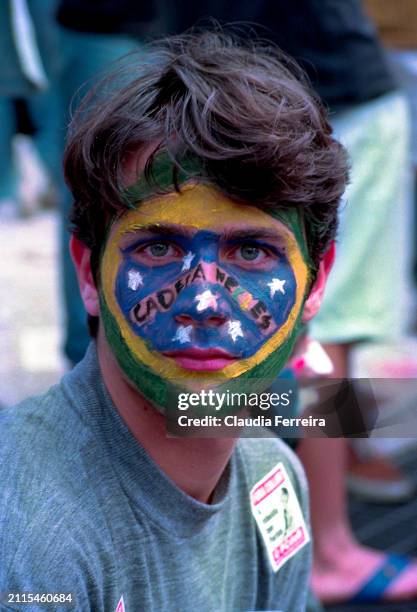 Portrait of an unidentified protester with face paint during a demonstration , Rio de Janeiro, Brazil, 1992. His face paint is modelled after the...