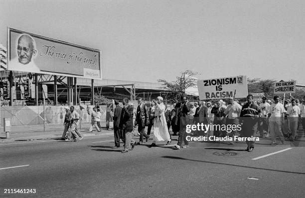 View of demonstrators, some with signs, as they participate in a march, organized by the African National Congress , during the World Conference...